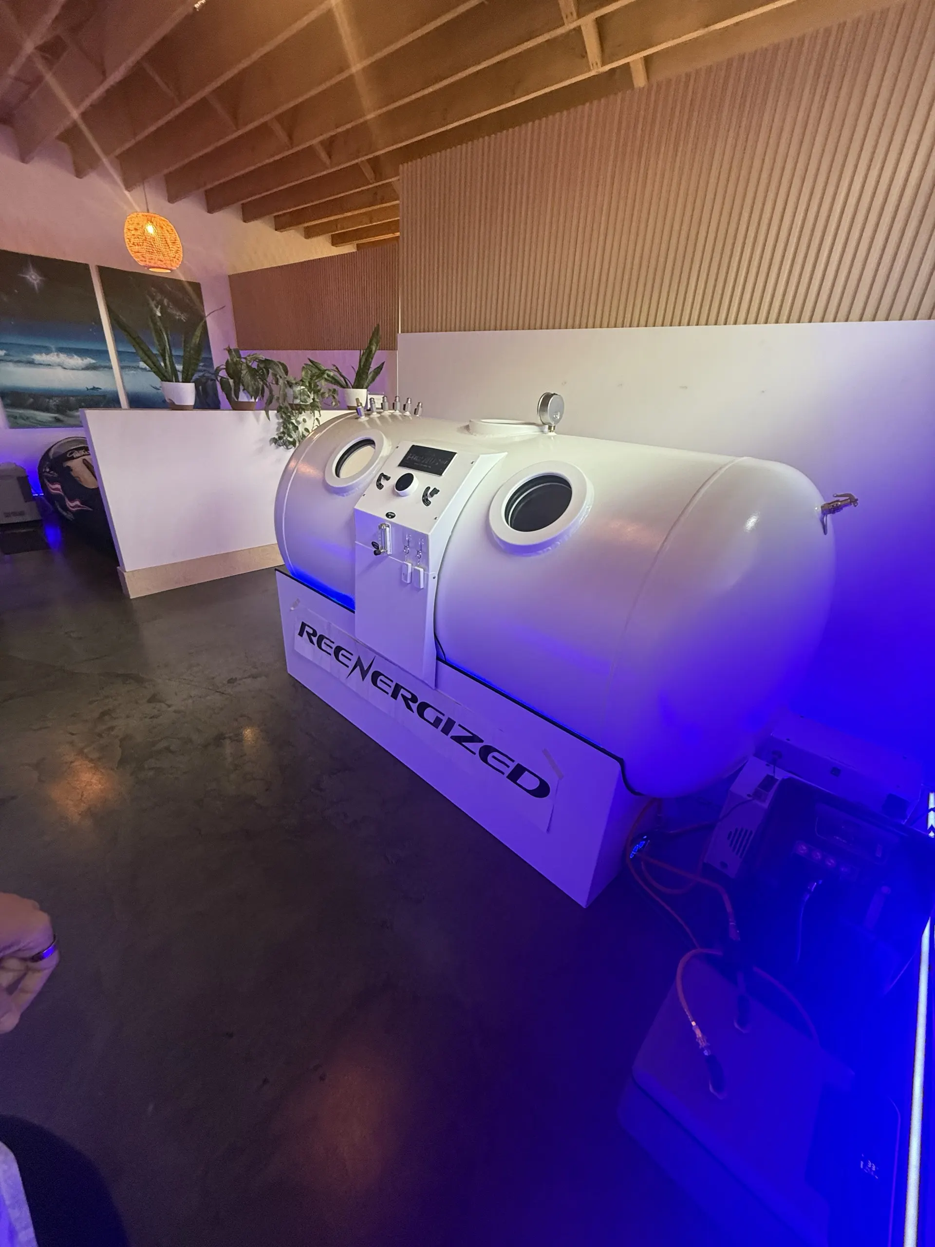 The blue-lit Fortius 2.0 ATA hard-shell hyperbaric chamber at the ReEnergized Long Beach studio